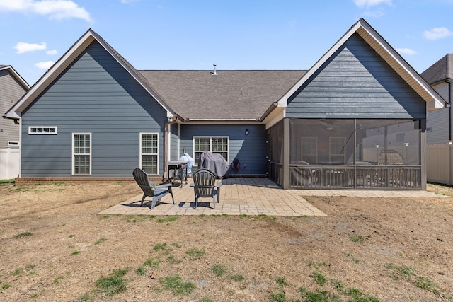 back of property featuring a sunroom, fence, a shingled roof, and a patio area