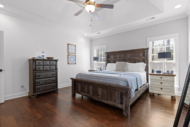 bedroom featuring a tray ceiling, hardwood / wood-style flooring, and visible vents