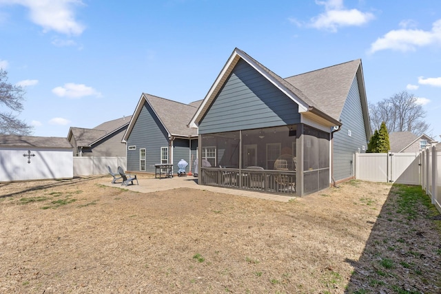 rear view of house with a gate, a patio, a fenced backyard, a yard, and a sunroom