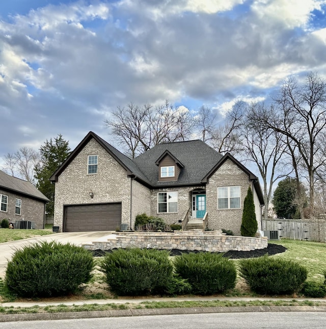 view of front of home with fence, concrete driveway, a shingled roof, a garage, and brick siding