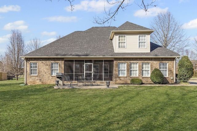 back of property featuring a patio, a yard, roof with shingles, a sunroom, and brick siding