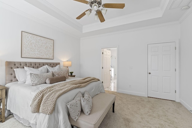 carpeted bedroom featuring ceiling fan, baseboards, a tray ceiling, and ornamental molding