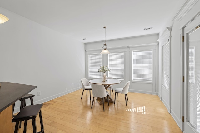 dining area featuring visible vents, light wood-type flooring, and baseboards