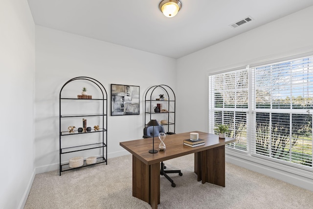 office featuring visible vents, light carpet, and baseboards