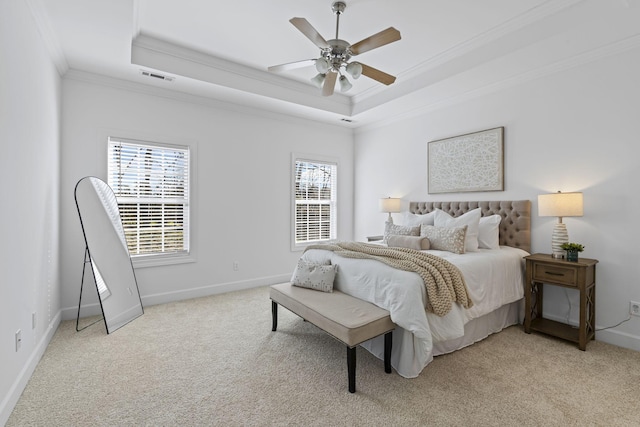 bedroom with a tray ceiling, crown molding, light colored carpet, and visible vents