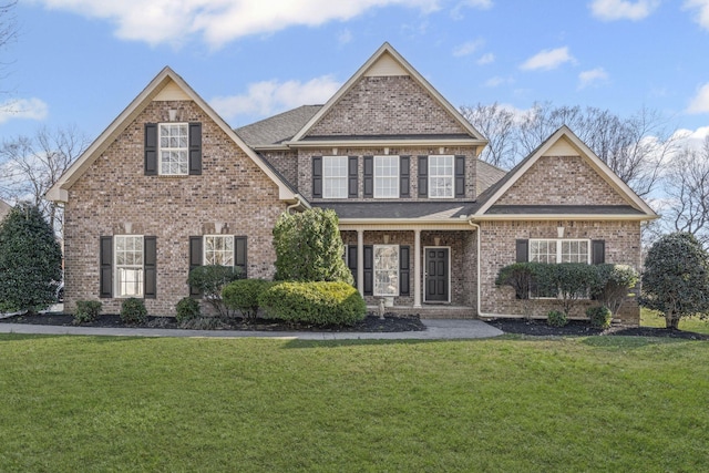 view of front facade featuring brick siding, a front lawn, and a shingled roof