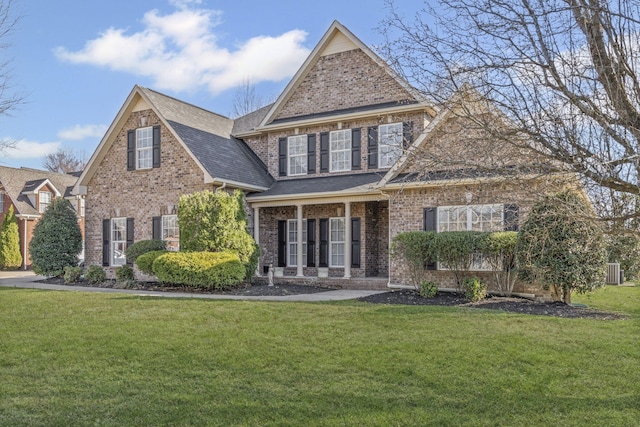 traditional-style home featuring brick siding, a front lawn, and a shingled roof