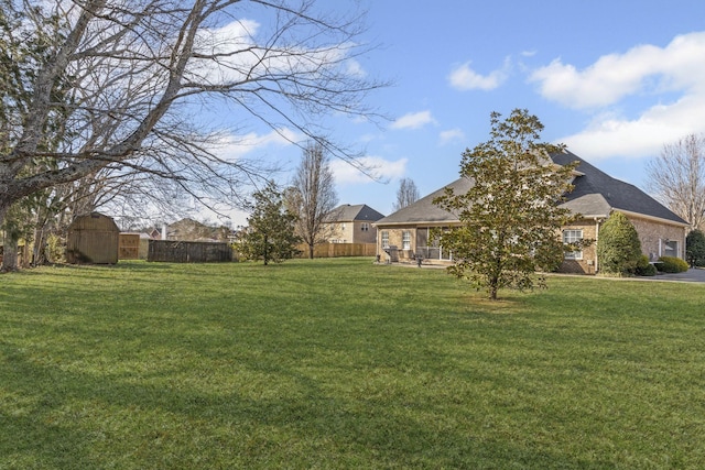 view of yard featuring an outdoor structure, a storage unit, and fence