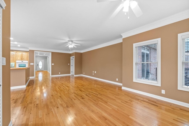 unfurnished living room with baseboards, light wood-style floors, ceiling fan, and crown molding