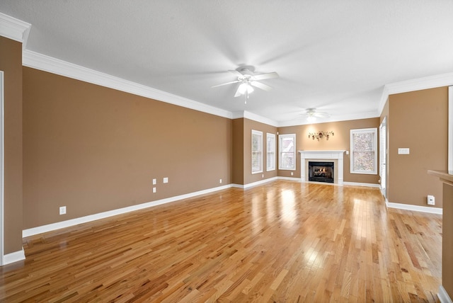 unfurnished living room featuring baseboards, light wood-style floors, ceiling fan, and ornamental molding