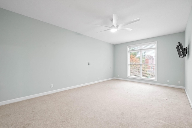 unfurnished room featuring baseboards, light colored carpet, and ceiling fan