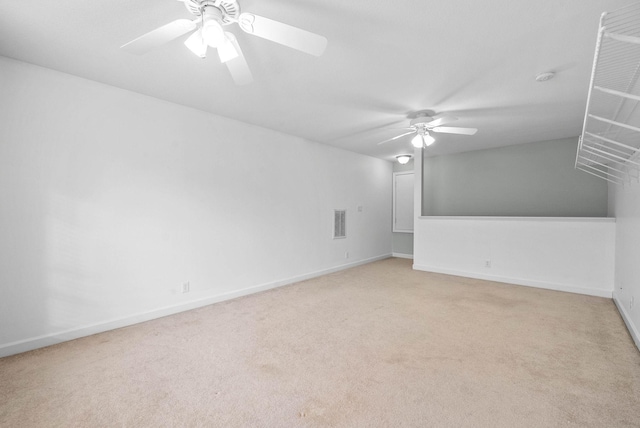 spare room with light carpet, baseboards, visible vents, and ceiling fan