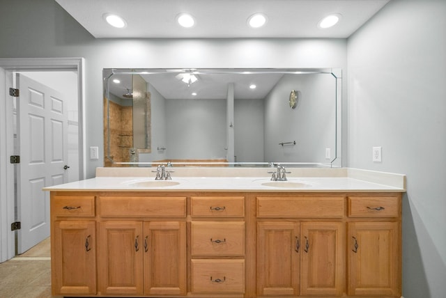 bathroom with a sink, ceiling fan, double vanity, and tile patterned floors