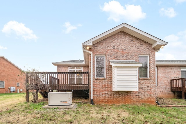 back of property with brick siding, a lawn, and a deck