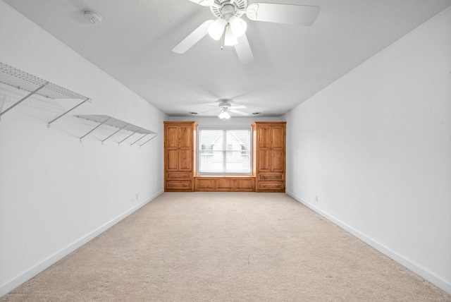 unfurnished room with light colored carpet, baseboards, and ceiling fan