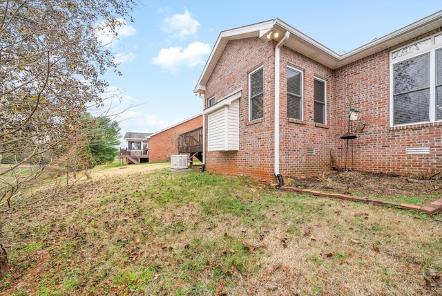 view of side of home featuring crawl space, a yard, and brick siding