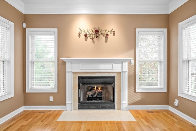 room details with a fireplace with flush hearth, wood finished floors, baseboards, and ornamental molding