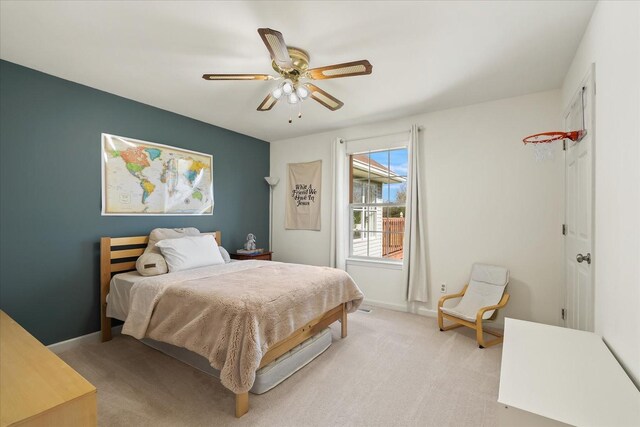 bedroom featuring light colored carpet, baseboards, and ceiling fan