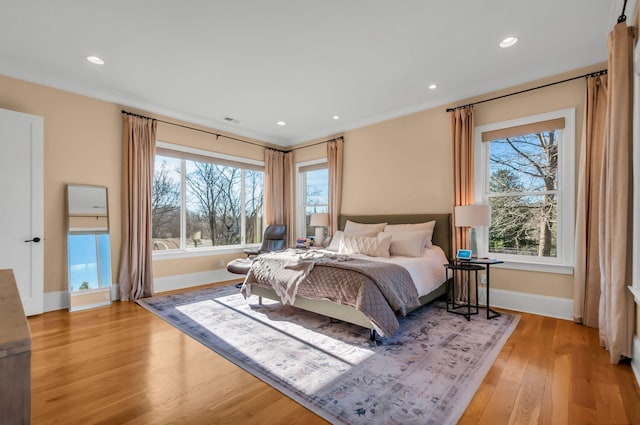 bedroom with recessed lighting, baseboards, multiple windows, and light wood-style floors