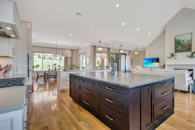 kitchen featuring light wood-type flooring, dark brown cabinetry, white cabinets, and a center island