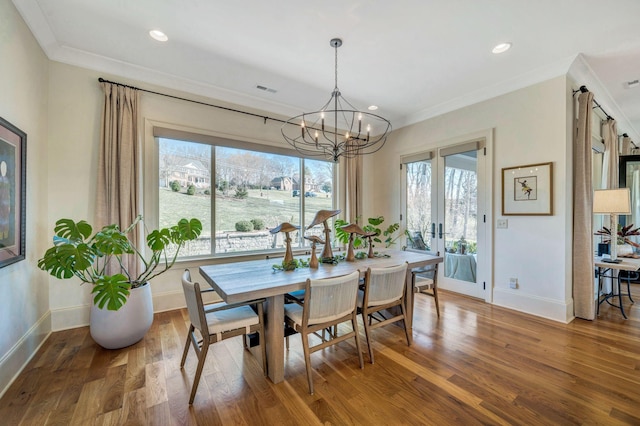 dining area featuring a chandelier, baseboards, wood finished floors, and ornamental molding