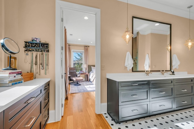 bathroom featuring vanity, wood finished floors, baseboards, and connected bathroom