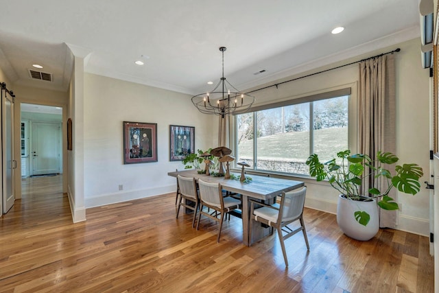 dining room with visible vents, light wood-style floors, and an inviting chandelier