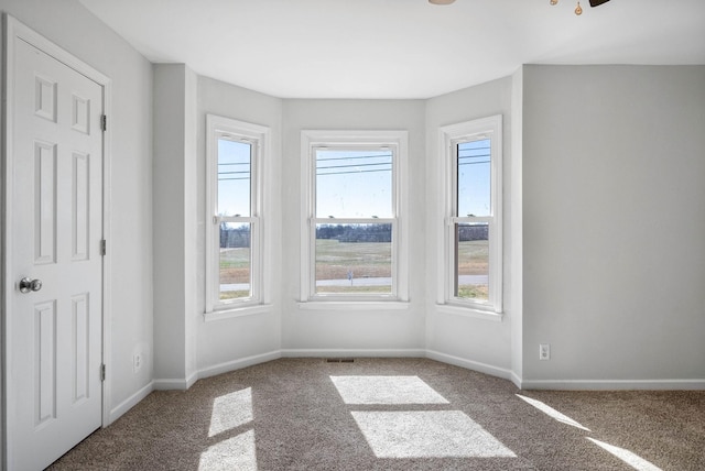 empty room with carpet, baseboards, and ceiling fan