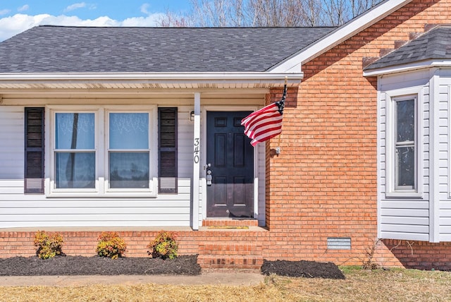 entrance to property featuring brick siding, crawl space, and a shingled roof