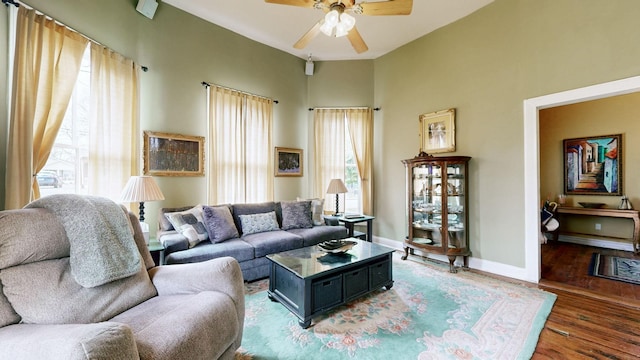 living area featuring a ceiling fan, light wood-style floors, and baseboards