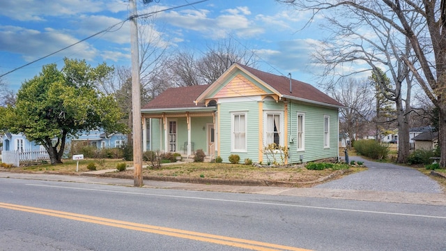 victorian house featuring a porch and fence