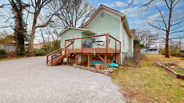 view of front of house featuring a deck, stairway, and fence