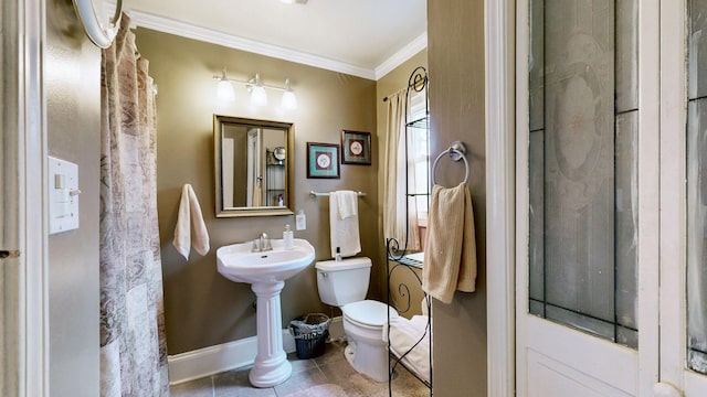 bathroom featuring baseboards, a sink, tile patterned flooring, ornamental molding, and toilet