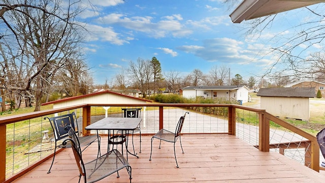 wooden terrace featuring an outbuilding and a storage unit