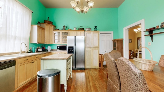 kitchen featuring a notable chandelier, light brown cabinets, a sink, dark wood-style floors, and stainless steel appliances