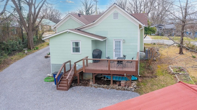 back of house featuring a wooden deck, roof with shingles, stairs, and fence