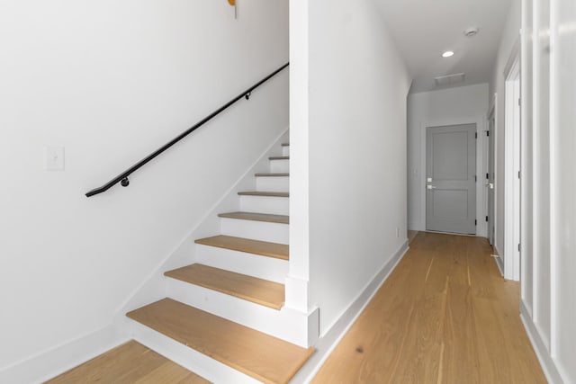 stairs with recessed lighting, visible vents, baseboards, and wood finished floors