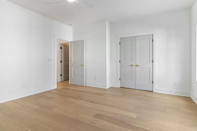 unfurnished bedroom with ceiling fan, baseboards, and light wood-style floors