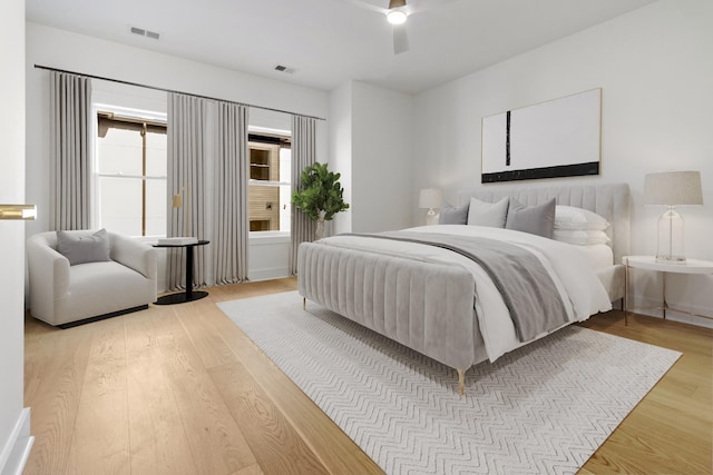 bedroom with visible vents, a ceiling fan, and wood finished floors