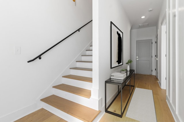 staircase featuring recessed lighting, wood finished floors, and visible vents