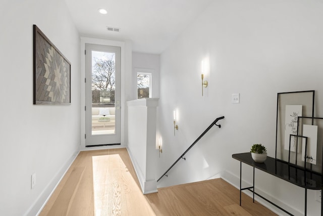 doorway with visible vents, light wood-type flooring, and baseboards