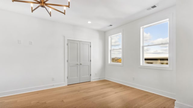 unfurnished room with recessed lighting, visible vents, light wood-style flooring, and baseboards