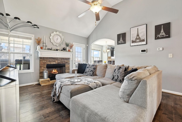 living room with arched walkways, ceiling fan with notable chandelier, baseboards, and dark wood-style flooring