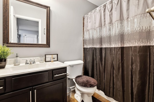 bathroom with a shower with shower curtain, toilet, and vanity