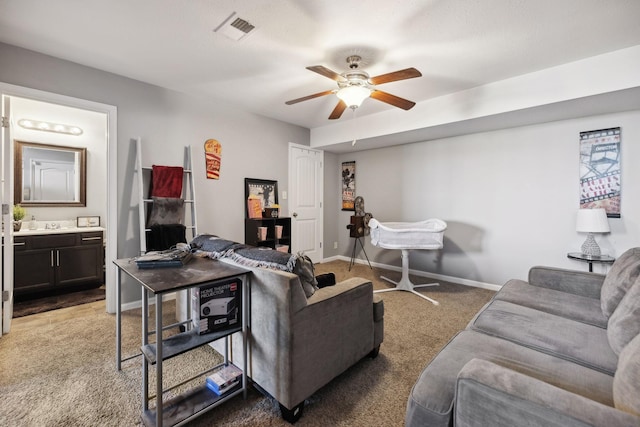 carpeted living room featuring visible vents, baseboards, and a ceiling fan