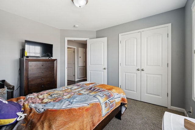 carpeted bedroom featuring baseboards and a closet