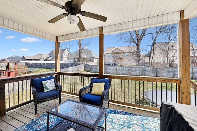 deck with a residential view, a ceiling fan, and a fenced backyard