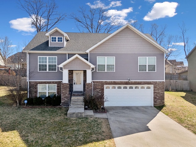 split foyer home featuring a front lawn, driveway, fence, an attached garage, and brick siding