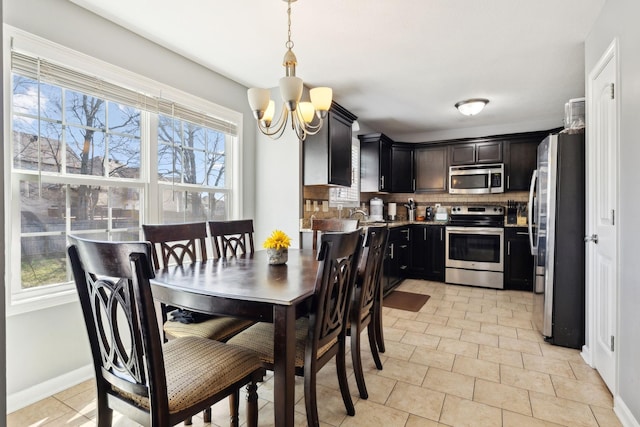 dining space featuring baseboards and a chandelier