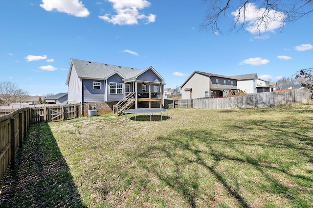 back of property with a wooden deck, stairway, a yard, and a fenced backyard